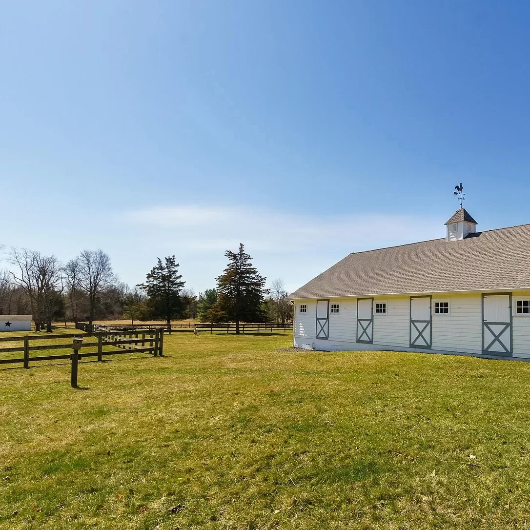 A barn overlooks fenced-in pastures.